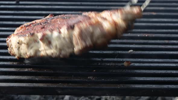 meat steak fried on a wire rack with smoke and fire