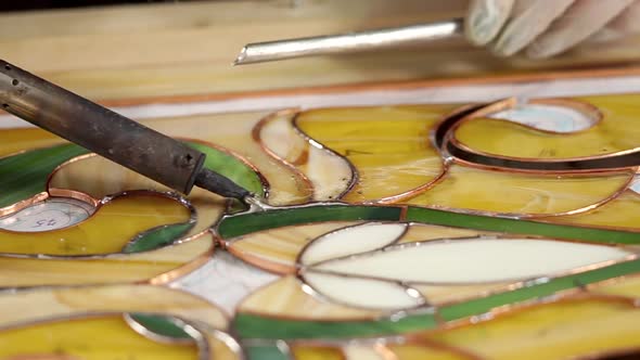 Master Is Creating a Stained-glass Panel Using Soldering Iron for Fixing