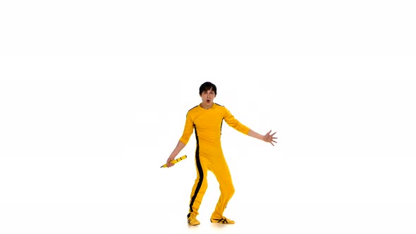 Man in Yellow Suit Training Karate and Expertly Twirling Nunchaku