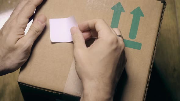 Hands Placing COVID19 VACCINE Label on the Box