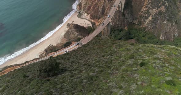 Aerial Drone Stock Video of Bixby Bridge Highway with water and shore below in Big Sur Monterrey Cal