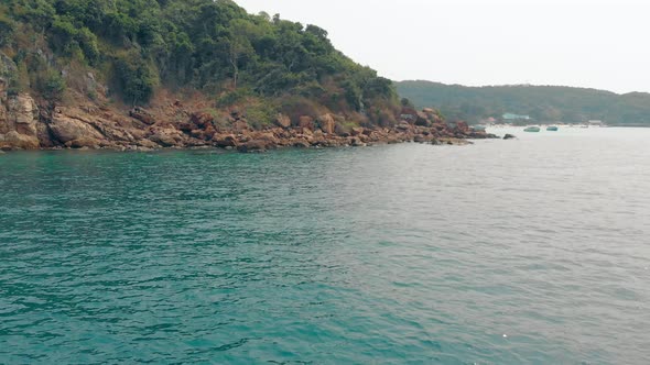 Awesome View of Clear Blue Sea Green Island and Brown Stones