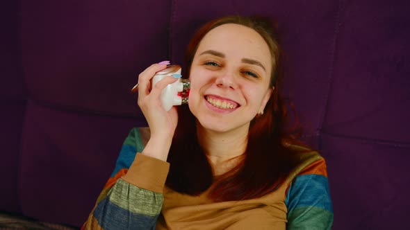 Cheerful Woman Using Face Massager