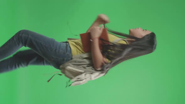 Side View Of Asian Girl Student Holding Book While Running To School On Green Screen Chroma Key