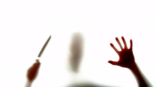 Abstract And Spooky Defocused Hand Holding Knife In Slow Motion