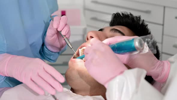 Close Up of Dentist Using Dental Curing UV Lamp on Teeth of Patient