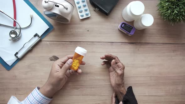 Doctor Giving a Medical Pill Container His Senior Patient