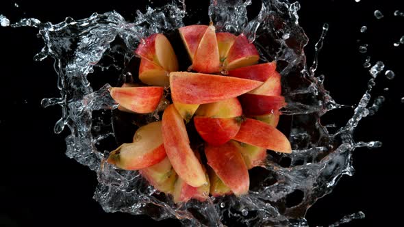 Super Slow Motion Shot of Rotating Exploded Red Apple Cuts and Splashing Water on Black at 1000Fps