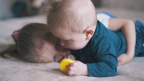 Lovely Girl Lies with Funny Brother on Comfortable Bed