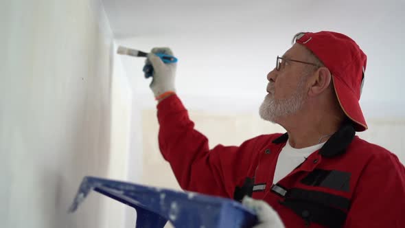 Retiree Paints the Wall with White Paint