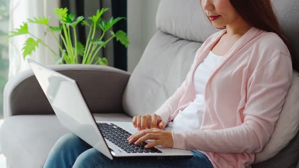 Young woman greeting in a video call in the living room at home	