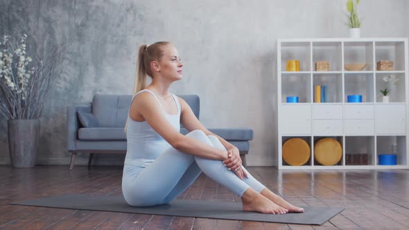 Young and sporty girl in sportswear is doing exercises at home.