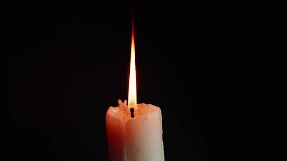 The showcases of colorful single candlelight on black background with the effect of light and slow m