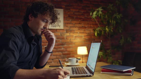 Young Successful Businessman Working in Office at Night