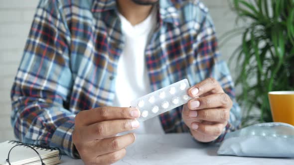 Young Man Hand Hold Pills of Blister Pack White Sited