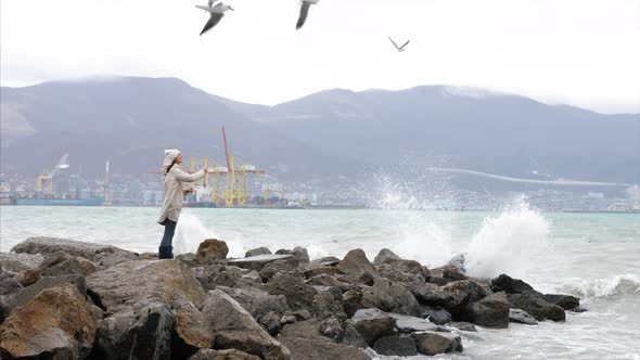 Young Woman is Feeding a Seagulls