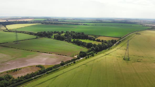 Drone Footage Flying Over Patchwork English Fields and Electric Pylons