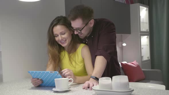 Couple in Kitchen Having Breakfast and Using Digital Tablet