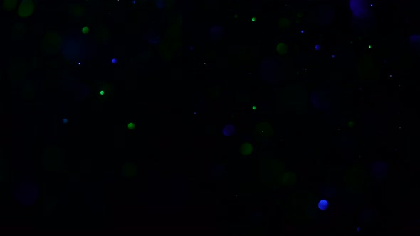 Beautiful Sparkle Dust on a Black Background in Bluegreen Light