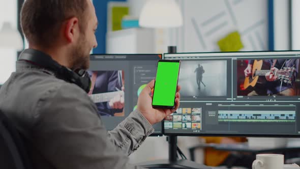 Video Editor Talking on Video Call Holding Smartphone with Green Screen