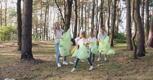 Team of Volunteers in Protective Gloves Collecting Garbage Into Plastic Bags All Over the Park