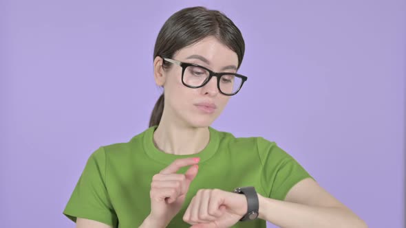 Young Woman Using Smart Watch on Pink Background