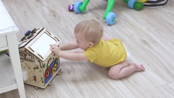 Baby Boy Playing with Wooden Busy House Montessori Educational Toy at Home