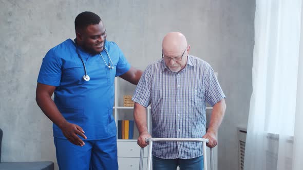 African-American caregiver and old disabled man in a wheelchair. Nurse and handicapped patient.