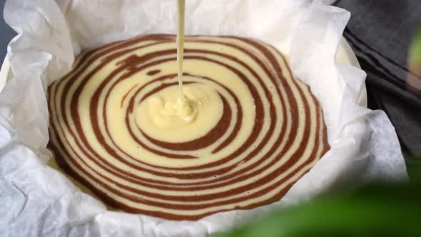 Making marble or zebra cake. Pouring white dough