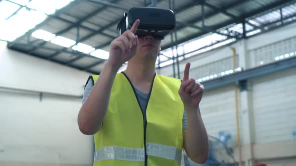Industrial Factory Worker Wearing VR Goggle Touching in Virtual Reality World Inside Factory