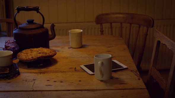 Coffee cup, digital tablet, food and teapot on table