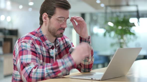 Stressed Male Designer with Laptop Having Headache