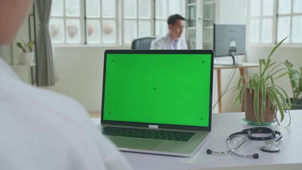 Close Up Asian Woman Doctor Having Video Conference On Laptop With Mock Up Green Screen Display