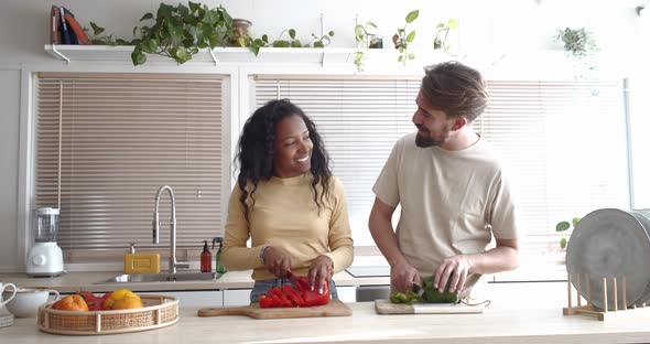 Multiethnic Heterosexual Couple Laughing and Cooking Together in an Apartment