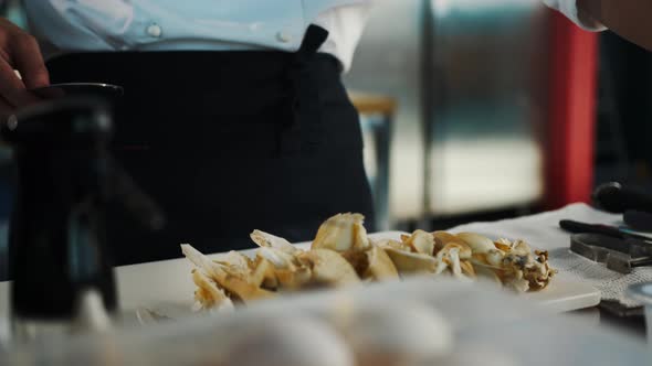 Professional kitchen, close-up: The chef cuts mushrooms, prepares a delicious dish in the restaurant