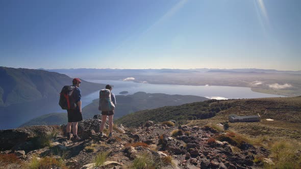 Static, hikers overlook Luxmore Hut and vast landscape, Fiordland, Kepler Track New Zealand