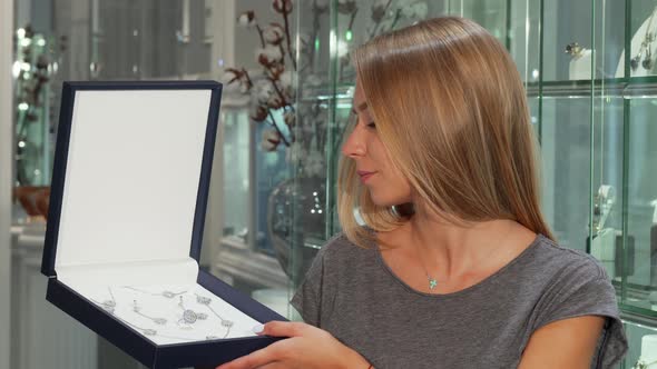 Gorgeous Happy Woman Smiling To the Camera Holding Expensive Jewelry Set