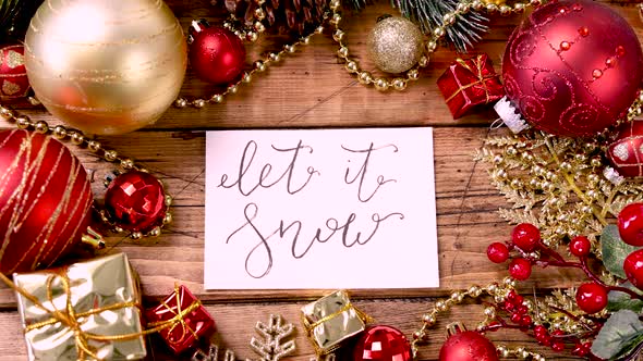 LET IT SNOW card with Christmas decorations around on wooden table zoom in