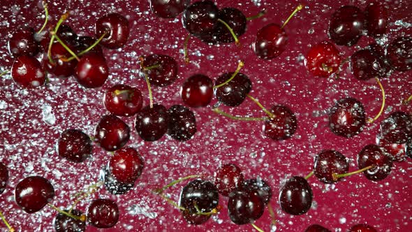 Super Slow Motion Shot of Flying Fresh Cherries and Water Side Splash at 1000Fps.