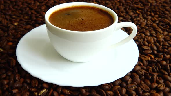 Cup with coffee on the background of coffee beans.