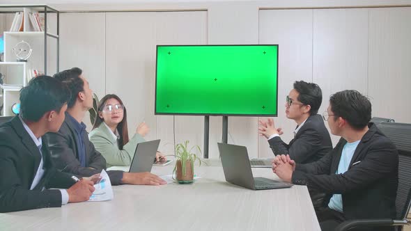 Young Asian Team Have Meeting In A Conference Room. They Share Opinions With Tv Mock Up Green Screen