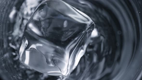 Super Slow Motion Detail Shot of Ice Cube Falling Into Glass With Alcohol Liquid at 1000 Fps