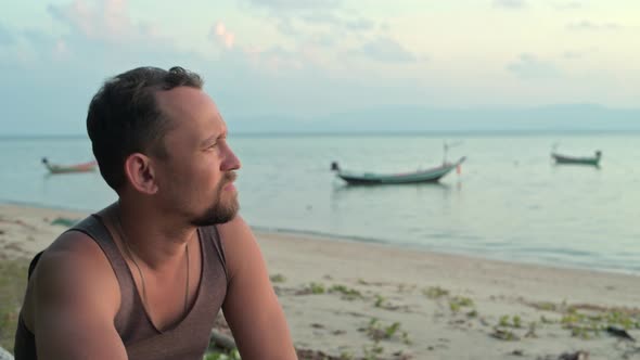 A Man Traveler on the Seashore in the Rays of the Setting Sun