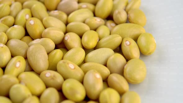 Uncooked peruvian bean in white plate. Mayocoba grains. Macro. Canary legumes