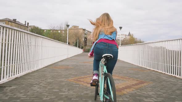 A Young Hipster Girl Riding a Fixed Gear Bike at City Centre Slow Motion