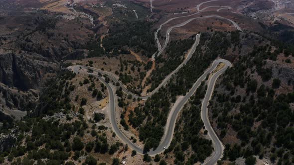 Aerial view of Road in the Mountain. Fly above Serpentine road in the Crete, Greece, Europe