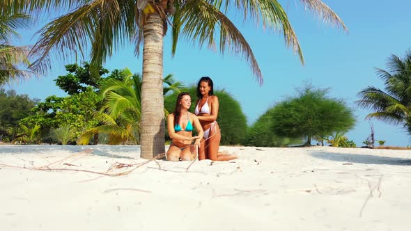 Women happy together on tropical resort beach voyage by blue green lagoon and white sand background 