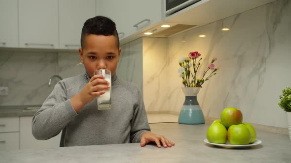 Kid Drinking Milk Smiling Enjoying Taste of Organic Product at Home