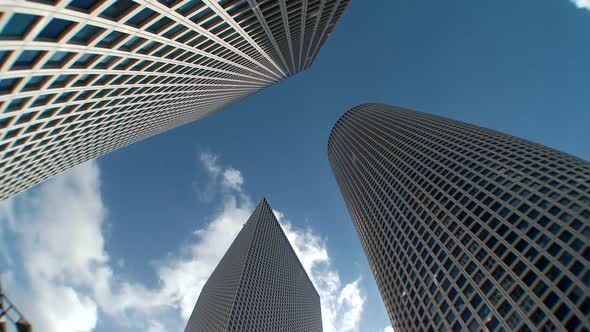 Time lapse of clouds from a low angle shot of skyscrapers in Tel Aviv