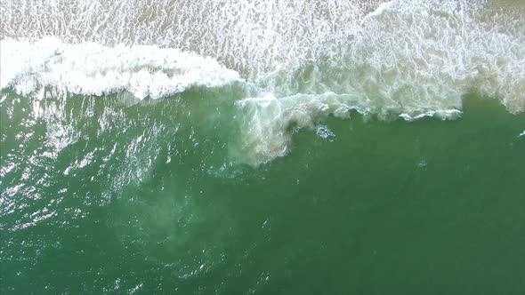 A look down as waves crash on the beach